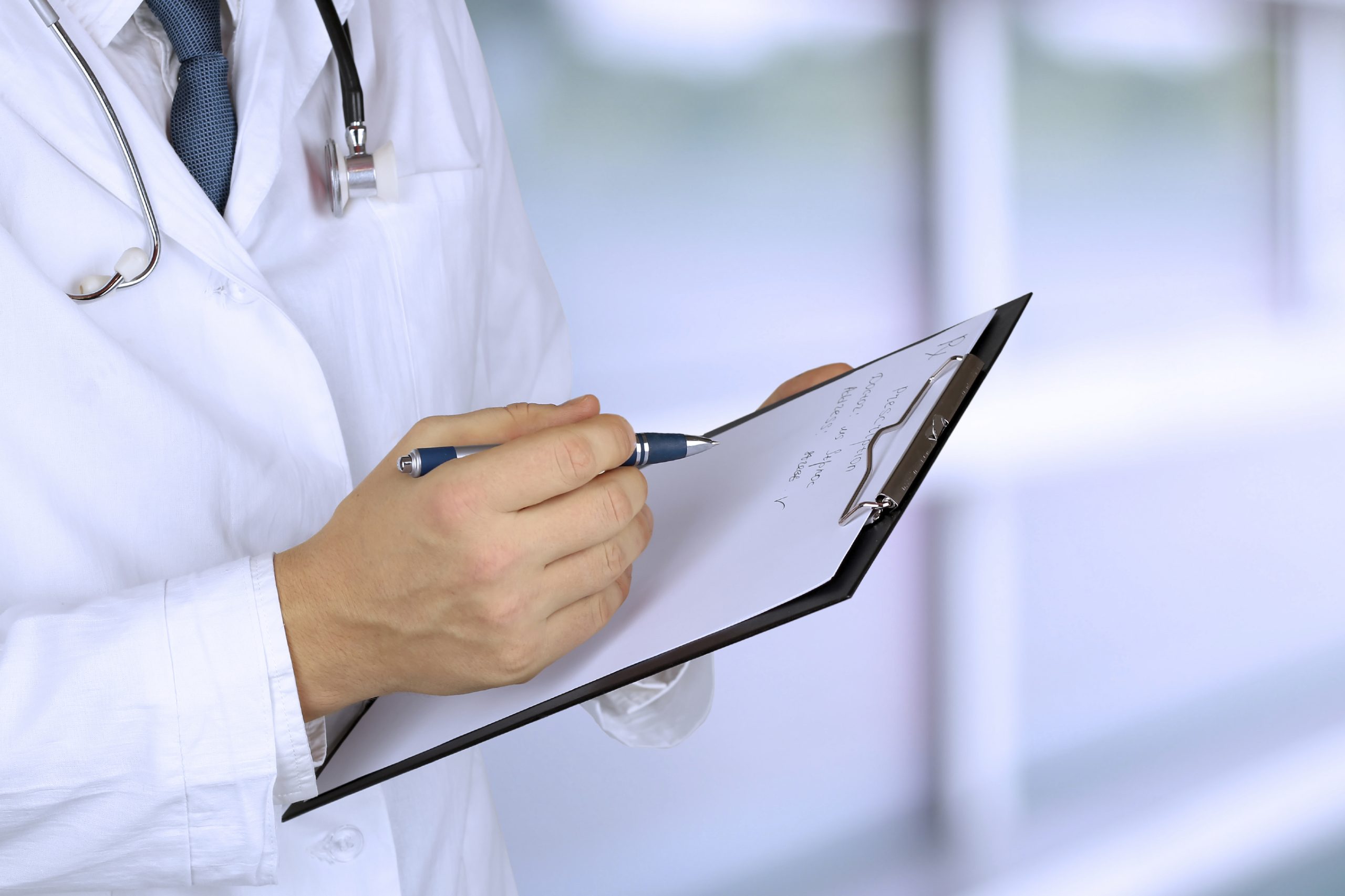 young medical doctor with a stethoscope around his neck holdi